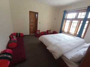 a bedroom with a large bed and a window at Hunza Ray's guest house in Dargai