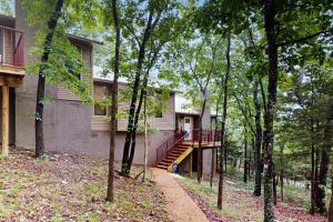 a house with a staircase in the middle of trees at Tucked Away Getaway in Kimberling City