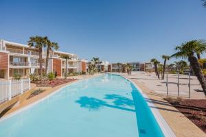 einen Pool in einem Resort mit Palmen und Eigentumswohnungen in der Unterkunft Wave Island H2 in Lido di Jesolo + 7 Fotos