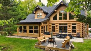 a log cabin with tables and chairs in the yard at Blue Bear Spa sauna private pool lake access in Wentworth