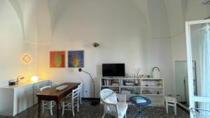 een woonkamer met een tafel, stoelen en een televisie bij Italianway - Sant'Oronzo Apartment in Lecce