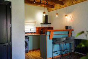 a kitchen with a sink and a counter with stools at Tuta Area Cottage in Kazbegi