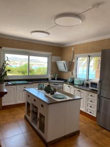 a large kitchen with white cabinets and a large island at Casa Vora Mar in Felanitx