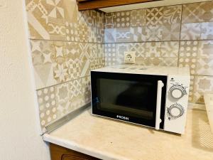 a microwave sitting on a counter in a kitchen at BLUE PANORAMA EMERALD with Amazing Sea View - Lower Ground Floor in Makri