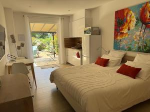 a bedroom with a bed and a kitchen with a refrigerator at Patios di Pruno Studio NINO in Figari