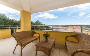 a balcony with chairs and a vase with flowers on it at Vilola in Umag