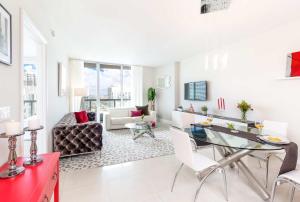 a white living room with a glass table and chairs at MVR Bright & Airy Condo with Views in Miami