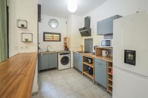 a kitchen with a sink and a washing machine at Beauséjour à vous - Cosy et Confort - Wiskeys in Sainte-Marie