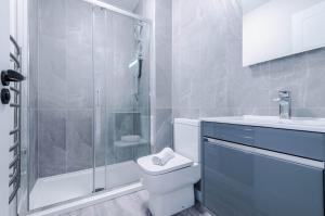a bathroom with a shower and a toilet and a sink at Elysée Suites - Modern 1 Bed Flat in Southport in Southport