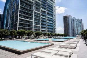 a large swimming pool with lounge chairs and tall buildings at MVR - Skyline & Spa for Brickell Perfection in Miami
