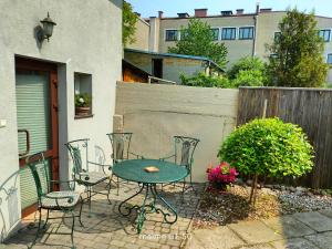 a patio with a table and chairs and a fence at Studio dwupokojowe z łazienką i kuchnią in Augustów