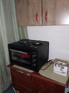 萨拉热窝The Pretty Place的黑微波炉,坐在橱柜顶上