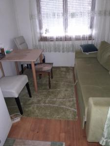 萨拉热窝The Pretty Place的一间带桌子和沙发的小客厅