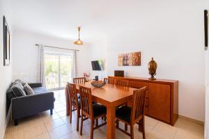 a dining room with a wooden table and chairs at Pool&Beach in Encosta de São José in Albufeira