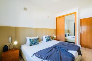 a bedroom with a large bed and a mirror at Pool&Beach in Encosta de São José in Albufeira +15 photos