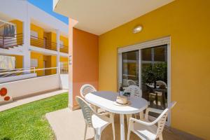 a dining room with a table and chairs on a balcony at Pool&Beach in Encosta de São José in Albufeira