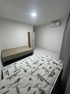 a small room with a bed with black writing on it at Apto Inteiro no centro de Caruaru in Caruaru