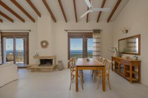 a dining room with a table and chairs and a fireplace at Apolis Villas & Suites Resort in Parga
