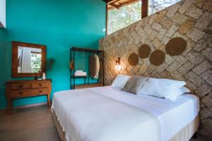 a bedroom with a white bed and a blue wall at Smart Hotel Reserva Ilhabela in Ilhabela