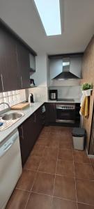 a kitchen with a sink and a stove top oven at Lunamar in San José