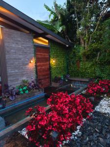 Un jardín con flores rojas frente a una casa. en Cabaña Celeste, en Rionegro
