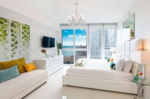 1 dormitorio blanco con sofá blanco y ventana en MVR - Sky-High Style in Brickell, en Miami