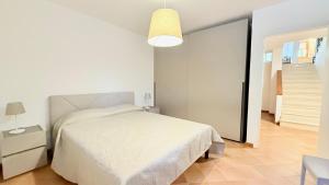 a bedroom with a white bed and a lamp at S354 - Sirolo, comodo quadrilocale a 100mt dal centro in Sirolo