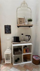 a white shelf with a bird cage on a wall at Bouganville in Rosignano Marittimo