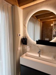 a bathroom with a sink and a mirror at Miramontino Mountain Suite in Rota d'Imagna