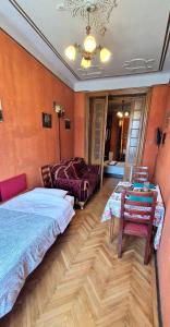 una camera da letto con un letto, un tavolo e un divano di Domum Unirea, across the street of Old City Center a Bucarest