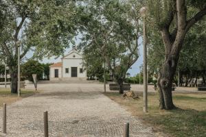 a building in the middle of a park with trees at Torreira Beach Apartment in Torreira