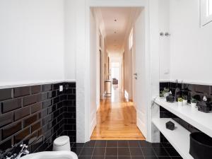 a bathroom with black and white tile and a hallway at Akicity Santarém Gemstone in Santarém +36 photos