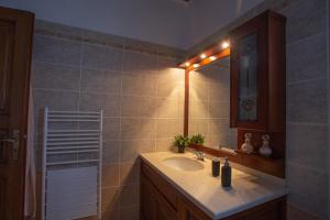 ein Badezimmer mit Waschbecken und Spiegel in der Unterkunft Luxurious Sea Side 3 Bedroom House Aegina Island in Vathí