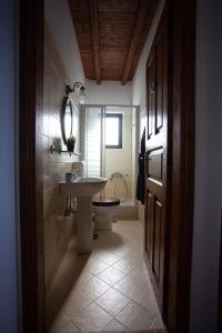 ein Badezimmer mit Waschbecken und Toilette in der Unterkunft Luxurious Sea Side 3 Bedroom House Aegina Island in Vathí