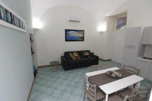a living room with a black couch and a table at Casa Verde in Sant'Agnello