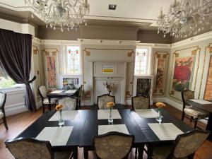 a dining room with a table and chairs and a chandelier at Boreland Lodge Hotel in Inverkeithing