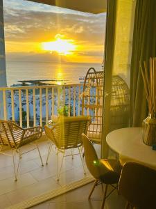 een balkon met een tafel en stoelen en uitzicht op de oceaan bij Exclusive ocean front apartment in Playa de las Americas