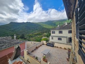 a view from the balcony of a house with mountains in the background at Jolie maison de village- Cap Corse Pietracorbara in Pietracorbara