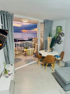 een woonkamer met een tafel en uitzicht op de oceaan bij Exclusive ocean front apartment in Playa de las Americas