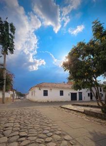 a cobblestone street in front of a white building at La Morada de la Villa 101 in Villa de Leyva
