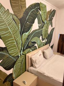 a living room with a couch and a mural of leaves at Duplex Apartment near Nizami street in Mekhrably