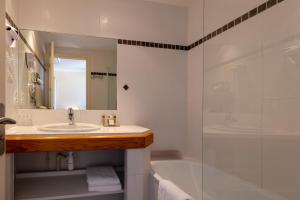 a bathroom with a sink and a tub and a shower at Family Golf Hotel in Royan +94 photos
