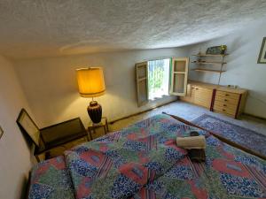 a bedroom with a bed and a lamp and a window at Nature Home Maitreya in Lorca