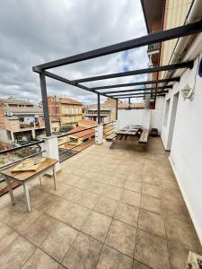 a balcony with benches and tables on a building at Casa Herrero Valderrobres in Valderrobres +25 photos