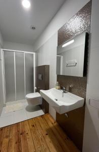 a bathroom with a white sink and a toilet at Hostel Rossio Alcobaça in Alcobaça +37 photos