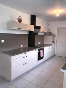 une cuisine avec des armoires blanches et un comptoir noir dans l'établissement Chambre double lit King size, à La Celle-sous-Gouzon