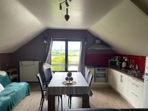 a kitchen with a table and chairs in a room at A l'orée du Bois in Landelies