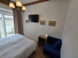 a bedroom with a bed and a blue chair at Ludanov apartma in Radlje ob Dravi