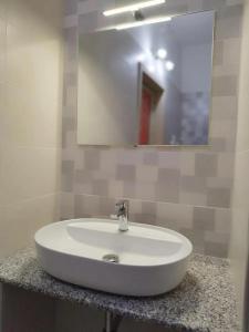 a white sink in a bathroom with a mirror at B&B Villa Martoglio in Belpasso