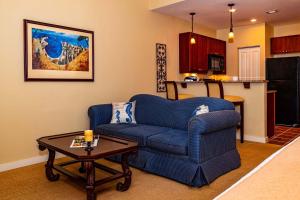 Una sala de estar con un sofá azul y una mesa. en Private balcony-grand views-pool-hot tub 5326- S, en St. Augustine